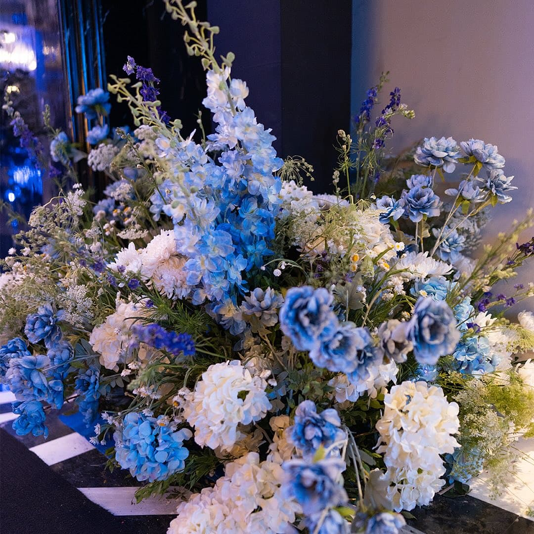 A layered blue and white floral arrangement showing the wedding's colour palette